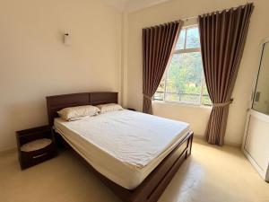a bedroom with a bed and a large window at Misty Hues in Kandy