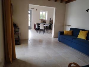 a living room with a blue couch and a table at Ty Véron, labellisé PMR in Asnières-la-Giraud