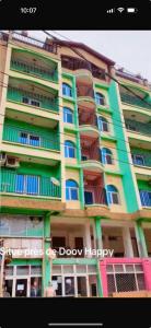 a large apartment building with blue and green windows at 2 chambres residence Dovv quartier Odja in Yaoundé +3 photos