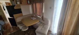 a living room with a table and a couch at Towyn Happy Days K3 in Rowen
