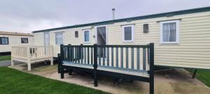 a mobile home with a bench in front of it at Towyn Happy Days K3 in Rowen