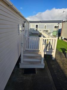 a porch with a white staircase next to a house at Towyn Winkups F07 in Rowen