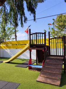 a playground with a yellow slide in a park at Camping El Jardín in El Campello