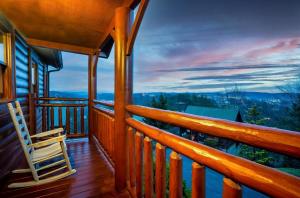 a rocking chair on a porch of a cabin with a view at Private Sauna Cabin Sleeps 34 Game Rooms in Pigeon Forge +37 photos