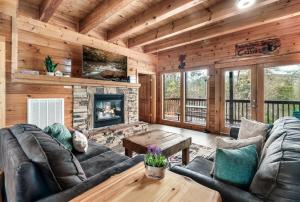 a living room with a fireplace in a log cabin at Private Sauna Cabin Sleeps 34 Game Rooms in Pigeon Forge