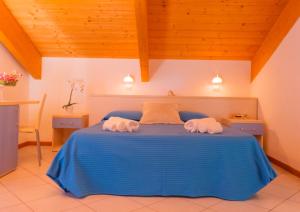 a bedroom with a blue bed with towels on it at Hotel Merano in Misano Adriatico