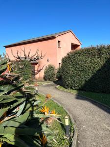 a house with a garden with flowers in front of it at Appartement en résidence d'exception avec piscine dans le cap corse in Sisco