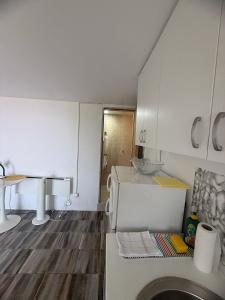 a kitchen with a washing machine and a wooden floor at Vila Pogled in Petrovac na Moru