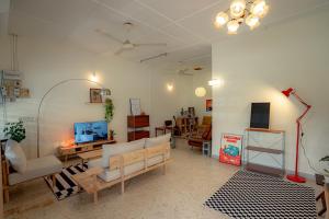 a living room with a couch and a tv at Tido Home, private queen room w bathroom, shared public area in Ipoh