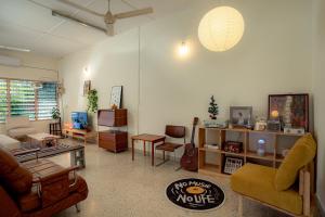 a living room filled with furniture and a guitar at Tido Home, private queen room w bathroom, shared public area in Ipoh +1 photo