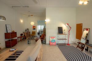 a living room with a couch and a table and chairs at Tido Home, private queen room w bathroom, shared public area in Ipoh