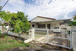 a white fence in front of a house at Tido Home, private queen room w bathroom, shared public area in Ipoh