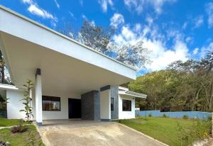 a white house with a driveway at Coral Breeze in Puntarenas
