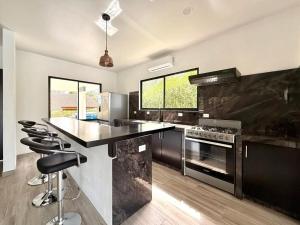 a kitchen with a counter and some chairs in it at Coral Breeze in Puntarenas