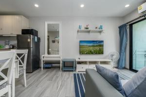 a living room with a couch and a kitchen at Cozy Studio Apartment E414 in Phuket