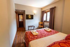 a bedroom with a bed with two towels on it at Tunqueley Hotel in San Martín de los Andes +18 photos