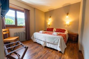 a bedroom with a bed and a window and a chair at Tunqueley Hotel in San Martín de los Andes