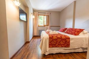 a bedroom with a bed and a window at Tunqueley Hotel in San Martín de los Andes