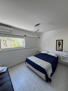 a bedroom with a blue bed and a window at Carpe Diem Gonnet in Joaquín Gorina