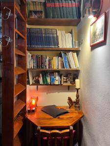 a desk with a book shelf filled with books at Grand Tour Suite Home in Spoleto