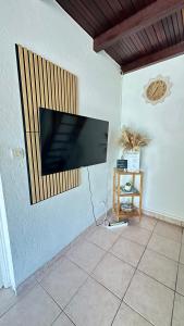 a flat screen tv hanging on a wall at Bungalow Marie in Saint-François