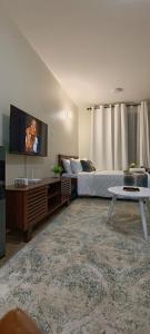 a bedroom with a bed and a flat screen tv at BlueByMis Studio Apartment in Muchatha