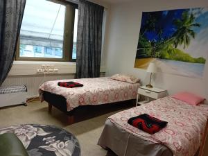 a room with two beds and a window at Hostel Yöpöllö in Kouvola