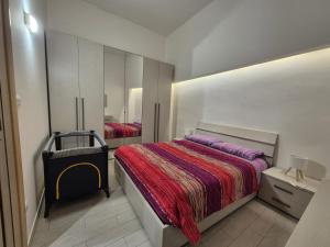 ein Schlafzimmer mit einem Bett, einer Kommode und einem Spiegel in der Unterkunft desHouse in Molfetta