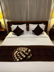 a bedroom with a bed with white sheets and pillows at Batan Bingin House in Ubud