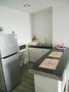 a kitchen with a refrigerator and a counter top at Aisyah Studio D perdana in Kota Bharu