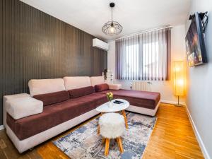 a living room with a couch and a table at Прайм, централен апартамент in Pleven