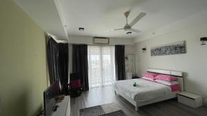 a bedroom with a bed with pink pillows and a ceiling at Aisyah Studio D perdana in Kota Bharu +2 photos