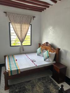 a bedroom with a large bed with a window at Munaa House Wiyoni in Lamu