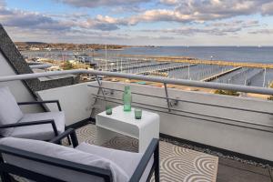 a balcony with chairs and a table and the ocean at Hafenblick in Kiel