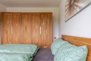 a bedroom with two beds and wooden cabinets at Ferienwohnung Anna in Heimbach