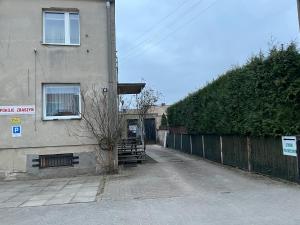 an empty street next to a building with a hedge at Studio pod Orzechem in Zbąszyń