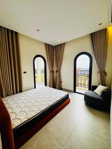 a bedroom with a large bed and two windows at Mây Home Hoa Lư in Phúc Trì