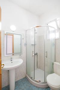a bathroom with a shower and a sink and a toilet at The Eden Hotel in Sarandë