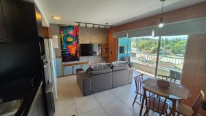 a kitchen and living room with a couch and a table at Apartamento 2 quartos Blumenau a 10 minutos da Vila Germânica in Blumenau