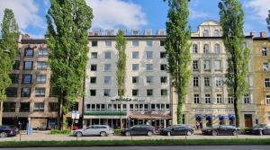 a large building with cars parked in front of it at myMINGA13 - Hotel & serviced Apartments in Munich