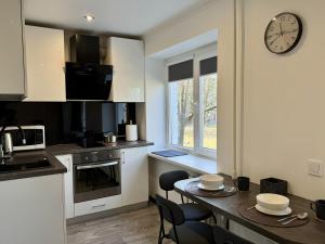 a kitchen with a table and a clock on the wall at Fine Apartment in Jelgava