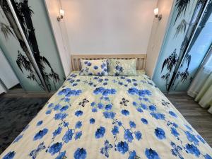 a bed with blue flowers on it in a room at Fine Apartment in Jelgava