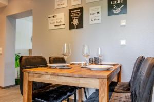 a wooden table with chairs and wine glasses on it at Ferienwohnung Anna in Heimbach