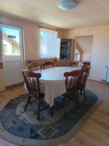 a dining room with a table and chairs at Timi Kulcsosház in Lăzarea
