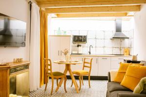 a kitchen and a living room with a table and chairs at Apartamentos Princesa Hayla in Caravaca de la Cruz