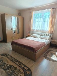 a bedroom with a large bed and a window at Timi Kulcsosház in Lăzarea