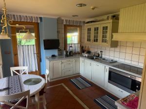 a kitchen with white cabinets and a table in it at Casa Santiago in Argoños