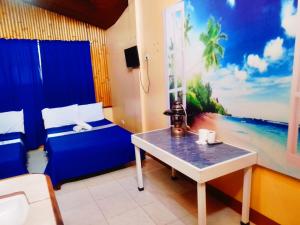 a room with a bed and a table and a window at Hotel Tagudan Kubo Corporation in Tagudin
