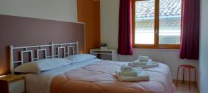 a bedroom with a large bed with towels on it at Affittacamere San Nicola in Montella