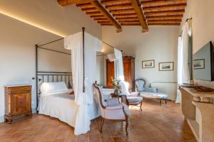 a bedroom with a bed and a table and chairs at Nobilis Charme Relais in Montepulciano